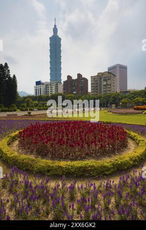 Ein farbenfrohes Blumenbeet im Vordergrund des Taipei 101-Gebäudes in der Innenstadt von Taipeh, Taiwan, Asien Stockfoto