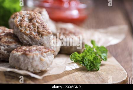 Hausgemachte Frikadellen (Tiefenschärfe) auf dunklem Holz Stockfoto