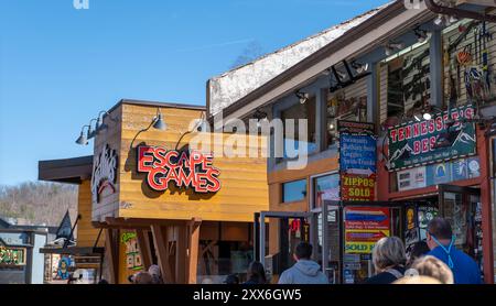 GATLINBURG, TN - 12. März 2024: Gehsteig-Szene mit Escape Games-Schild und Türen zu mehreren Geschäften. Stockfoto