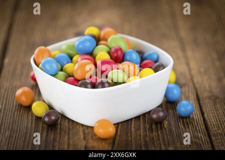 Cocolate beschichtet Erdnüsse auf rustikalen Holzmöbeln Hintergrund (Nahaufnahme) Stockfoto