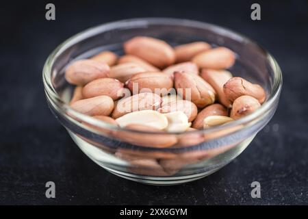 Teil der Erdnusssamen auf rustikalem Hintergrund (selektiver Fokus, Nahaufnahme) Stockfoto