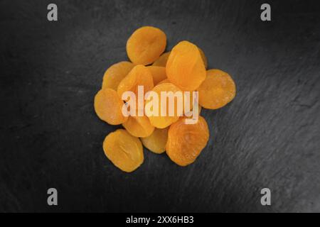 Teil der getrockneten Lebensmitteln (Aprikosen) als detaillierte Nahaufnahme auf einem Schiefer Tafel (selektive Fokus) Stockfoto