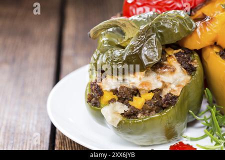 Gefüllte Paprika (mit Fleisch, Kräutern und Käse) auf hölzernen Hintergrund Stockfoto