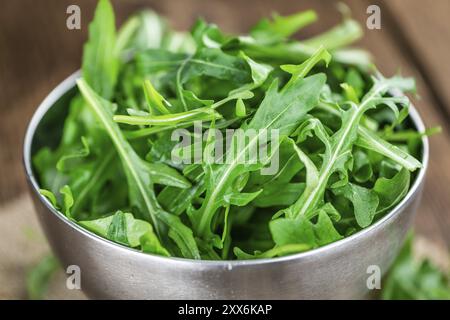 Frischer Arugula auf einem alten Holztisch als detaillierte Nahaufnahme Stockfoto