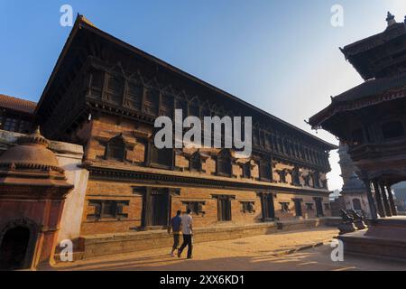 Bhaktapur, Nepal, 28. Oktober 2013: Menschen gehen an einem hellen Morgen am 55 Window Palace am Bhaktapur Durbar Square vorbei. Vor dem 2015. September Stockfoto