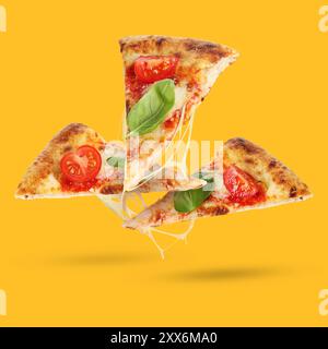 Scheiben köstlicher Pizza in der Luft auf orangefarbenem Hintergrund Stockfoto