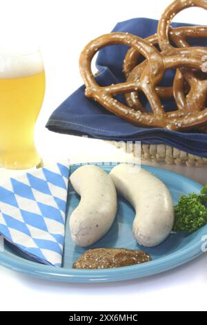 Weißwurst mit süßem Senf und Brezeln vor weißem Hintergrund Stockfoto