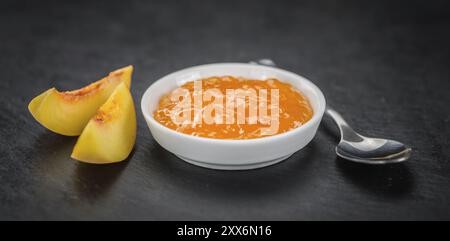 Pfirsichjam auf einer Vintage-Schieferplatte als detaillierte Nahaufnahme, selektiver Fokus Stockfoto