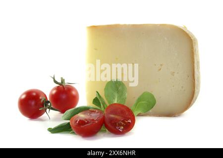 Stück Käse mit Tomaten und Lammsalat auf weißem Hintergrund Stockfoto