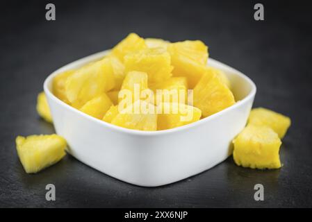 Teil der geschnittenen Ananas als detaillierte Nahaufnahme auf einer Schieferplatte, selektiver Fokus Stockfoto