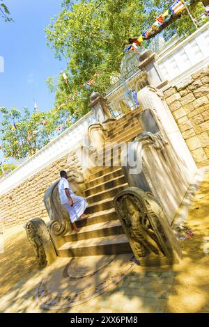 Anuradhapura, Sri Lanka, 7. Februar 2015: Männliche buddhistische Männer, die eine westliche Treppe hinauf zum heiligen Jaya Sri Maha Bodhi Baum über der alten Hauptstadt gehen Stockfoto