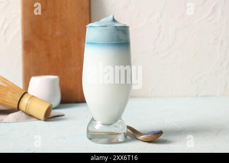 Glas blauer Dalgona Matcha Latte und Holzlöffel mit Pudermatcha auf Lichttisch Stockfoto