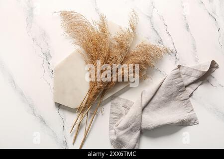 Brett mit trockenem Schilf und Serviette auf hellem Hintergrund Stockfoto