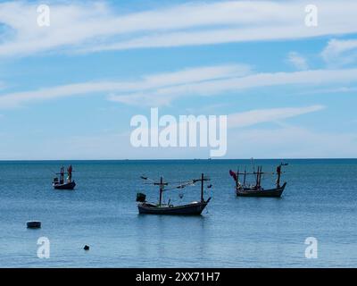 Landschaft mit traditionellen bunten thailändischen alten Holzfischbooten an Land bei Ebbe. Traditionelle thailändische Langschwanzfischboote im tropischen Meer Stockfoto