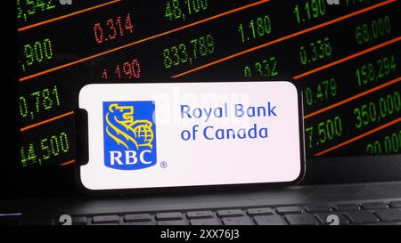 China. August 2024. In dieser Fotoabbildung wird das Logo der Royal Bank of Canada auf einem Smartphone mit Börse und Laptop-Tastatur angezeigt. Quelle: SOPA Images Limited/Alamy Live News Stockfoto