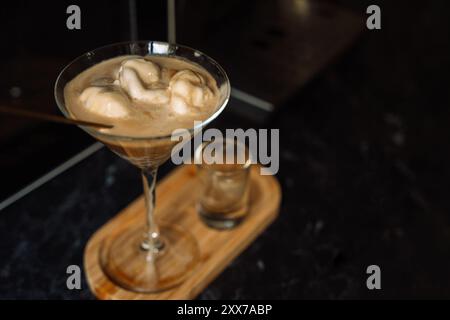 Hausgemachtes Desserteis mit Kaffee im Glas auf einem Holztablett. Stockfoto