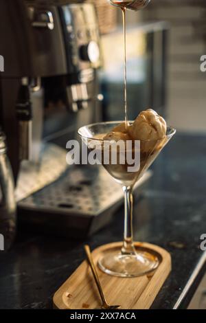 Das Kaffeeis wird vor der Kaffeemaschine mit Zuckersirup getränkt. Stockfoto