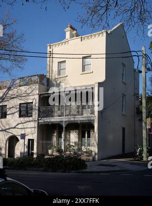 Sydney Hills, Sydney, ein großes dreistöckiges Terrassenhaus, das in der Nachmittagssonne auf der Riley Street gebadet ist, mit einem zweiten Eingang in der Seitenstraße Stockfoto