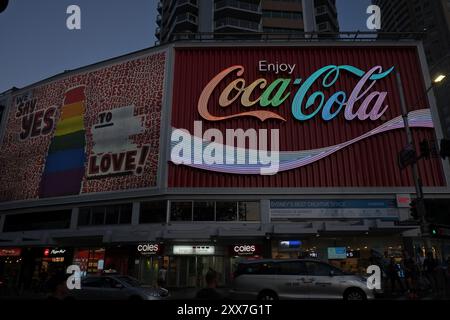 Das Kings Cross Coke Schild leuchtet in LGBTQI+ Farben A während mardi Gras Stockfoto