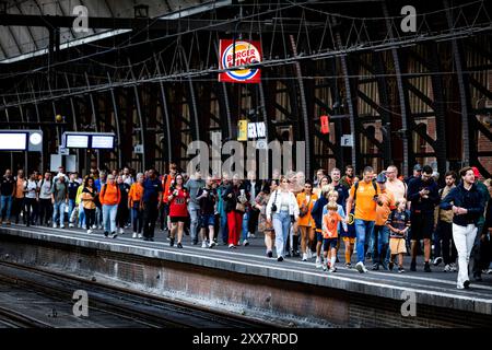 AMSTERDAM - Rennfans am Amsterdamer Hauptbahnhof fahren mit dem Zug nach Zandvoort aan Zee. Die NS fährt auf dieser Strecke während des Formel-1-Rennwochenendes in Zandvoort zwölf Züge pro Stunde. Das bedeutet, dass alle fünf Minuten ein Zug abfährt. Durch die zusätzliche Anzahl von Zügen sollte die große Anzahl der erwarteten Formel-1-Fans zum und von der Rennstrecke fahren können. ANP RAMON VAN FLYMEN Stockfoto