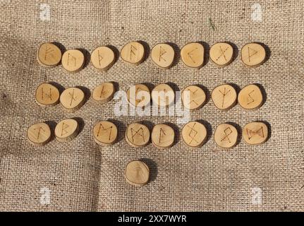 Wikingerrunen in Holzkreise auf einem Sacktuch-Hintergrund. Stockfoto