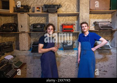 Wiltingen, Deutschland. August 2024. Die Studenten Jakob Kramp (r) und Paul Hallmanns stehen in ihrer Schreibmaschinenwerkstatt. Ob Remington, Underwood, Olivetti, Olympia, Hermes, Continental, Mercedes, Adler oder Erika – sie sammeln, reparieren und verkaufen mechanische Schreibmaschinen aus und auf der ganzen Welt. (Zu dpa Text: Zwei junge Männer sind Schreibmaschinenfans) Credit: Harald Tittel/dpa/Alamy Live News Stockfoto