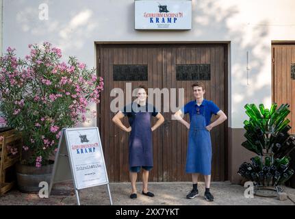 Wiltingen, Deutschland. August 2024. Die Studenten Jakob Kramp (r) und Paul Hallmanns stehen vor ihrer Schreibmaschinenwerkstatt. Ob Remington, Underwood, Olivetti, Olympia, Hermes, Continental, Mercedes, Adler oder Erika – sie sammeln, reparieren und verkaufen mechanische Schreibmaschinen aus und auf der ganzen Welt. (Zu dpa Text: Zwei junge Männer sind Schreibmaschinenfans) Credit: Harald Tittel/dpa/Alamy Live News Stockfoto