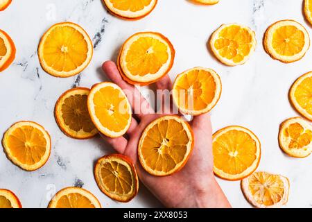 Eine Hand hält dehydrierte Orangenscheiben Stockfoto
