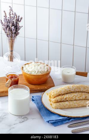Pfannkuchen mit Hüttenkäse auf einem Teller, Milch und Hüttenkäse Stockfoto
