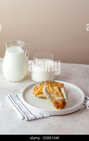 Hausgemachter Kuchen auf einem Teller, Milch in einem Glas daneben. Gesund br Stockfoto