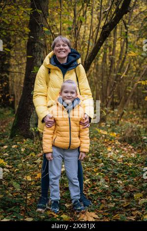 Mutter und Sohn genießen den Herbsttag im Wald Stockfoto