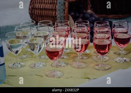 Weingläser gefüllt mit Wasser und rotem Sirup bei einer Veranstaltung im Freien Stockfoto