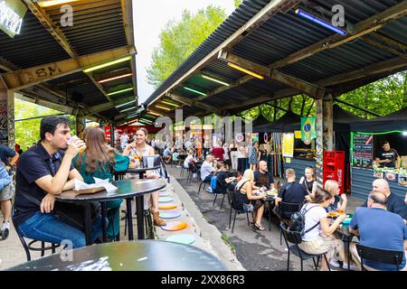 Menschen essen auf dem Open-Air-Markt Nocny Market (Nachtmarkt) auf den ehemaligen Bahnsteigen des Hauptbahnhofs in Warschau, Polen Stockfoto