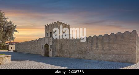 Außenfassade des Ateshgah Feuertempels in Baku, Aserbaidschan, ein historischer zoroastrischer Tempel. Die Steinstruktur verfügt über einen Steinzaun, eine bogenförmige Tür und einen Turm mit Tür und kleinen Fenstern Stockfoto