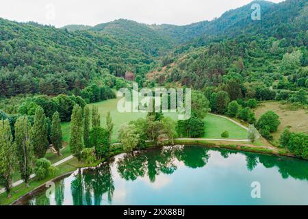 Aus der Vogelperspektive auf den Bergsee von Belcaire in den französischen Pyrenäen. Drohnenaufnahme der Berglandschaft mit grünen üppigen Wäldern und Wäldern in der Region Ariege in Stockfoto