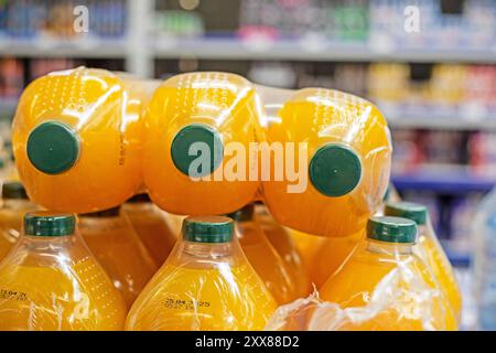 Orangen- und Multivitaminsaft in Plastikflaschen im Supermarkt Stockfoto