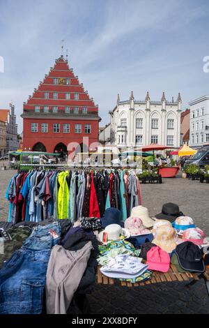 Greifswald, Deutschland. August 2024. Blick über den Markt mit dem Wochenmarkt zum Rathaus (l). Unter dem Motto „Street Art in Friedrichs Zeit“ feiert Greifswald in diesem Jubiläumsjahr an zwei Tagen das Stadtfest zu Ehren von Caspar David Friedrich. Das Festival findet auf dem Marktplatz und an anderen Orten im Stadtzentrum statt. Quelle: Stefan sauer/dpa/Alamy Live News Stockfoto