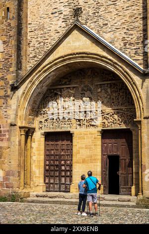 Frankreich, Aveyron, Conques, Les Plus Beaux Villages de France, Abteikirche Sainte-Foy aus dem 11. Jahrhundert, von der UNESCO zum Weltkulturerbe erklärt, betrachten einige Pilger aus Saint-Jacques das Tympanon des Jüngsten Gerichts und seine 124 Figuren aus dem 12. Jahrhundert Stockfoto