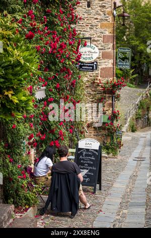 France, Aveyron, Conques, mit der Bezeichnung Plus Beaux Villages de France, vor dem Restaurant Le Comptoir de Germain mit roten Rosen und Bed and Breakfast Alice & Charles Stockfoto