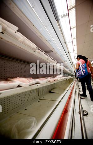 Lebensmittel werden in Venezuela zu einem politischen Thema, da die Regierung private Lebensmittelunternehmen verstaatlicht, die des Hortens beschuldigt werden. Tomme mathyller i en av de Private Supermarkedene. Stockfoto