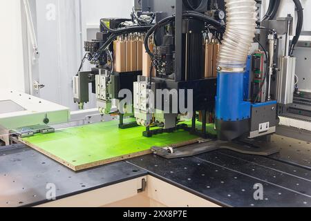 CNC-Holzmaschine in der Tischlerei. Produktionslinie der Holzfabrik. CNC-automatische Holzbearbeitungsmaschine in der Fertigungsindustrie Stockfoto