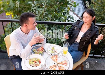 Glückliches junges paar Mittagessen im Restaurant im Freien Stockfoto