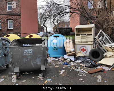 SIEMIANOWICE SLASKIE, POLEN - 12. DEZEMBER 2023: Unordentliches kommunales Abfallgebiet mit Kleiderspendenbehälter und verlassenen Bauabfällen in Siemia Stockfoto