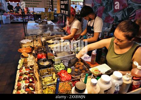 LONDON, Großbritannien - 13. JULI 2019: Die Verkäufer verkaufen Lebensmittel auf dem Boiler House Marktplatz in Brick Lane, London. Brick Lane ist eine beliebte Alternative Foodie und s Stockfoto