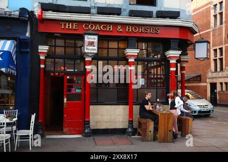LONDON, Großbritannien - 14. JULI 2019: Besucher besuchen den Coach and Horses Pub in Soho, London. Es ist ein typischer Londoner Pub. Es gibt mehr als 7.000 Pubs in Londo Stockfoto
