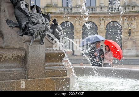 Frankreich, Manche, Cherbourg-en-Cotentin, Cherbourg Regenschirmfabrik, Herstellung von Luxusschirmen, Ein Paar mit Regenschirmen in der Stadt Stockfoto