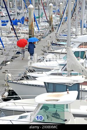 Frankreich, Manche, Cherbourg-en-Cotentin, Cherbourg Regenschirmfabrik, Herstellung von Luxusschirmen, Ein Paar mit Regenschirmen am Yachthafen Stockfoto