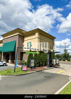 NORWALK, CT, USA - 21. AUGUST 2024: Starbucks Kaffeebau mit Einfahrt am Sommertag mit blauem Himmel und geschwollenen Wolken Stockfoto