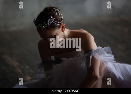 Die junge Ballerina zieht spitzenschuhe an. Stockfoto