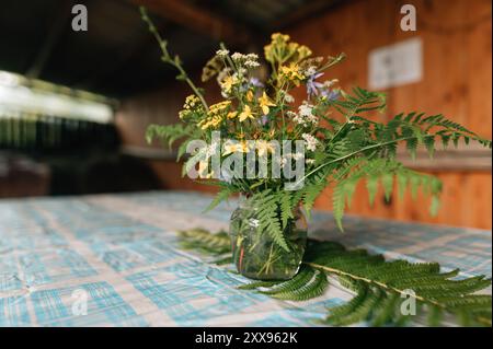 Stillleben mit Blumenstrauß und Gras auf dem alten Holztisch. Hochwertige Fotos Stockfoto